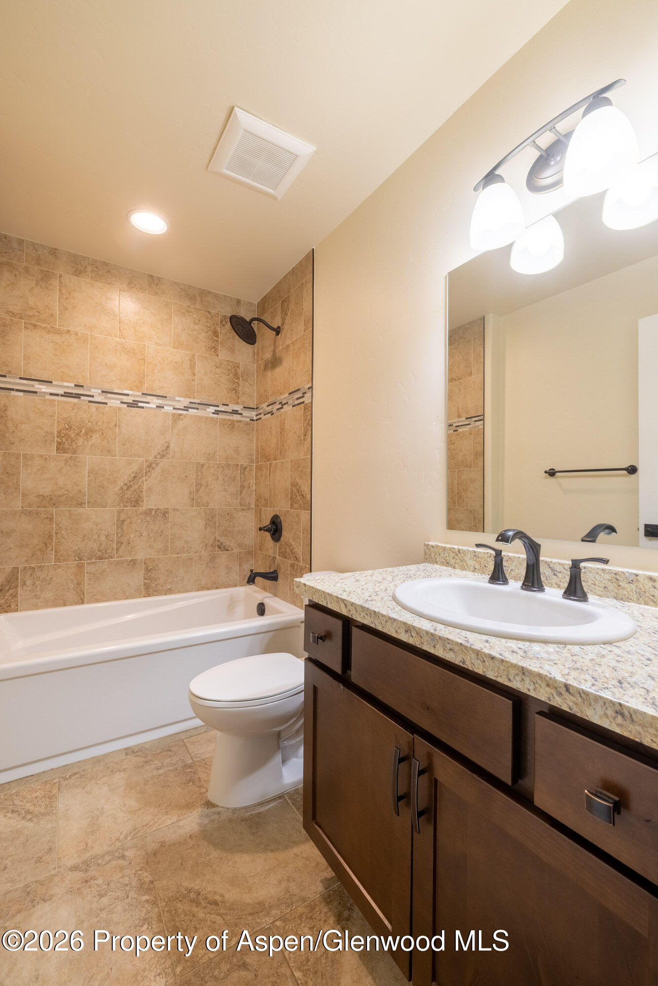 2016 Ballard Avenue Silt, CO 81652 - Photo 15 of 23 a bathroom with a granite countertop sink a toilet a mirror a bathtub and shower