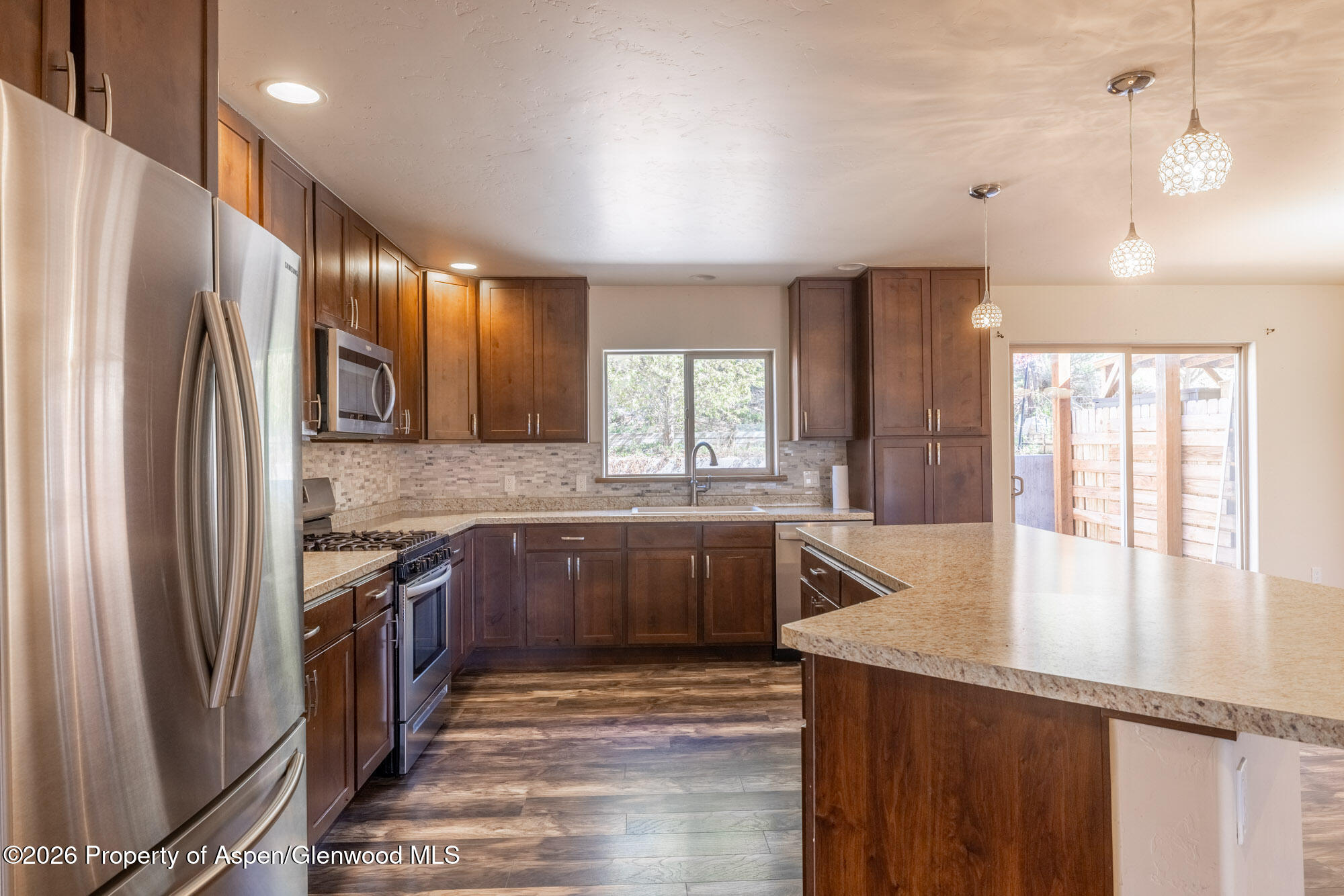 2016 Ballard Avenue Silt, CO 81652 - Photo 2 of 23 a kitchen with stainless steel appliances granite countertop a refrigerator a sink dishwasher a stove and white countertops with wooden floor
