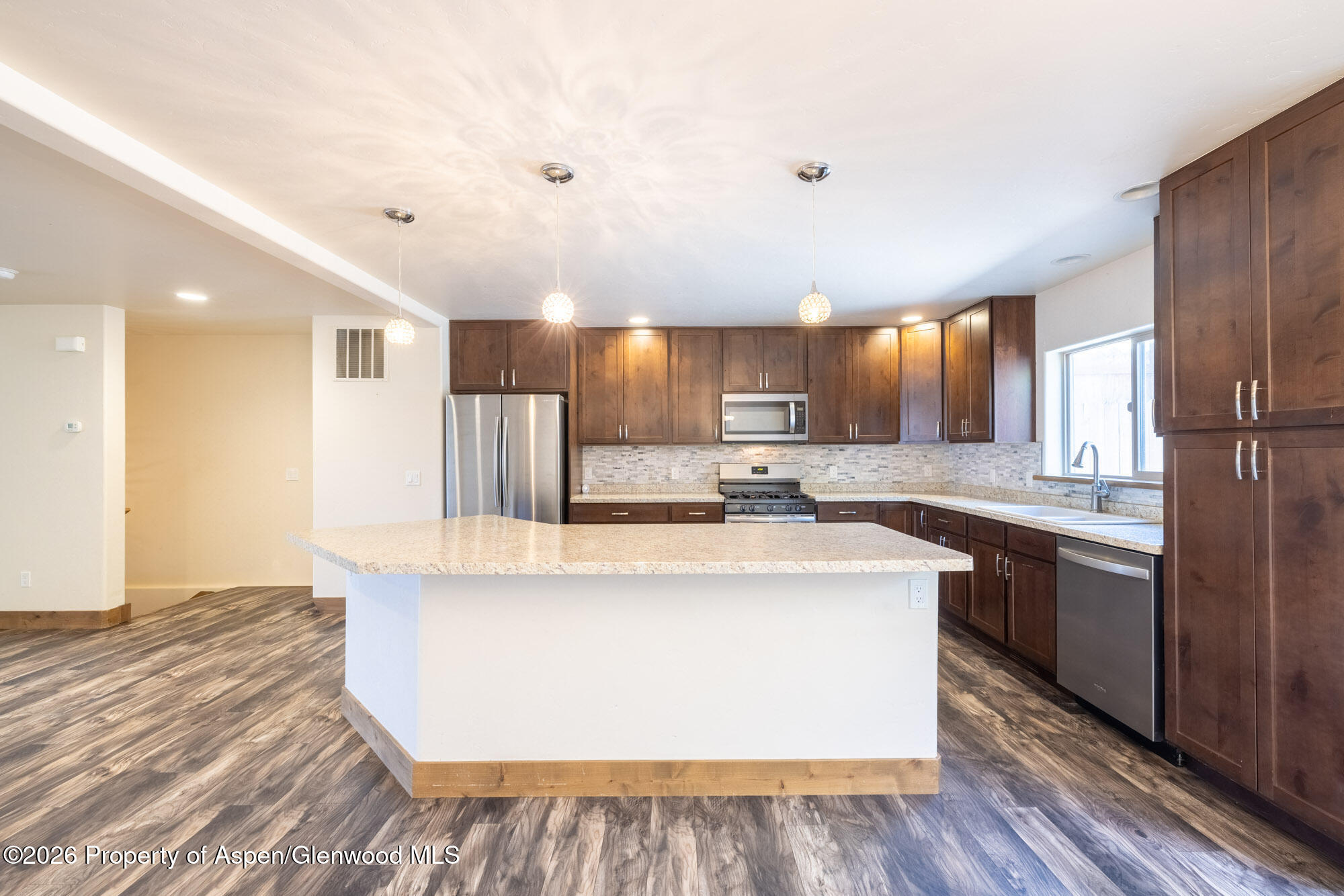 2016 Ballard Avenue Silt, CO 81652 - Photo 4 of 23 a large kitchen with stainless steel appliances a large counter top a stove and a refrigerator