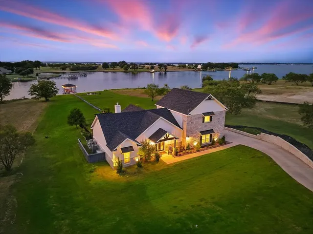 an aerial view of a house with a garden and lake view