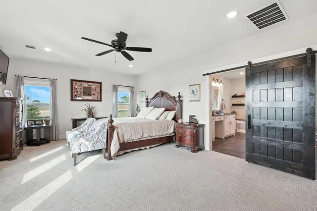 a spacious bedroom with a bed and dresser