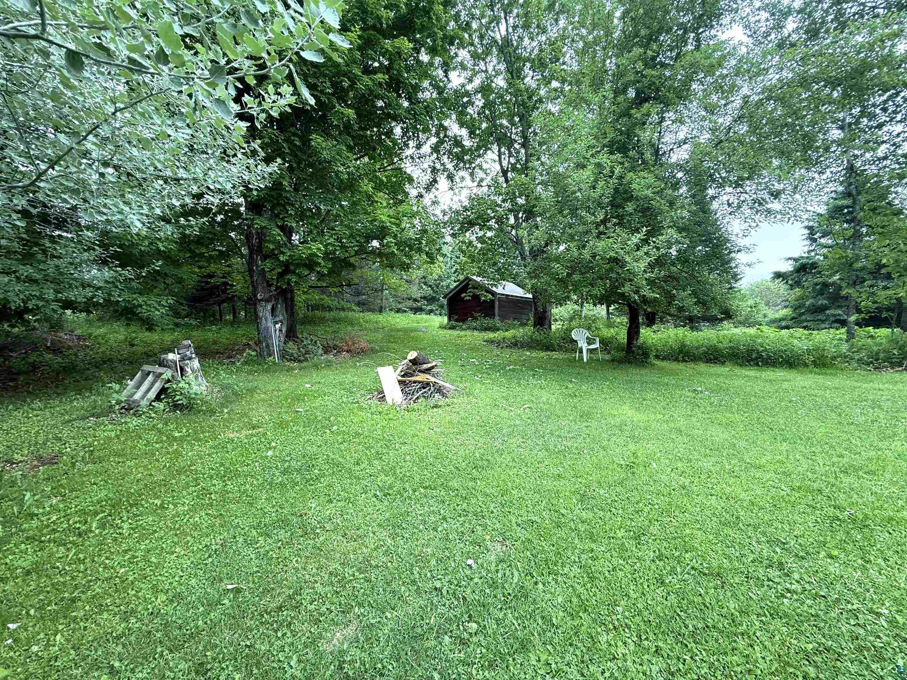 3541 Bent Trout Lake Road Barnum, MN 55707 - Photo 27 of 41 Expansive grassy yard with mature trees and a rustic shed structure