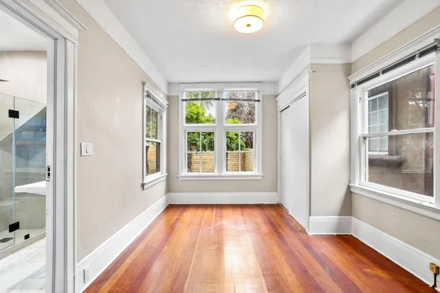 a kitchen with stainless steel appliances kitchen island a table chairs and a refrigerator