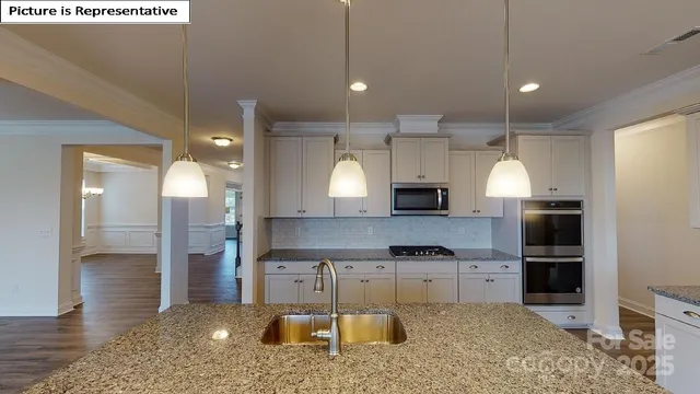 a kitchen with kitchen island granite countertop a sink cabinets and stainless steel appliances