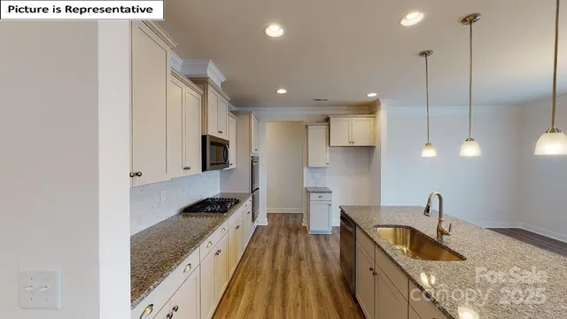a kitchen with granite countertop a sink and a stove top oven