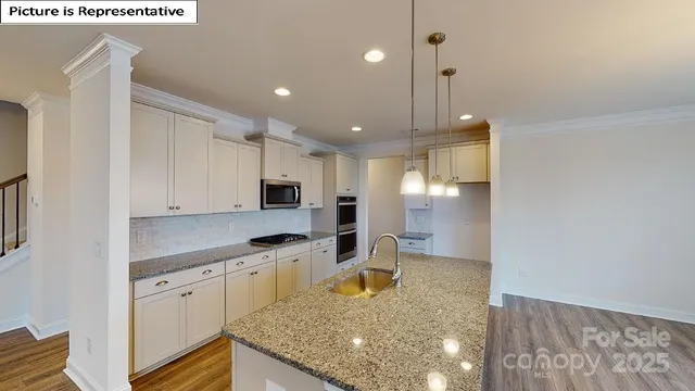 a kitchen with kitchen island granite countertop a sink window and stainless steel appliances