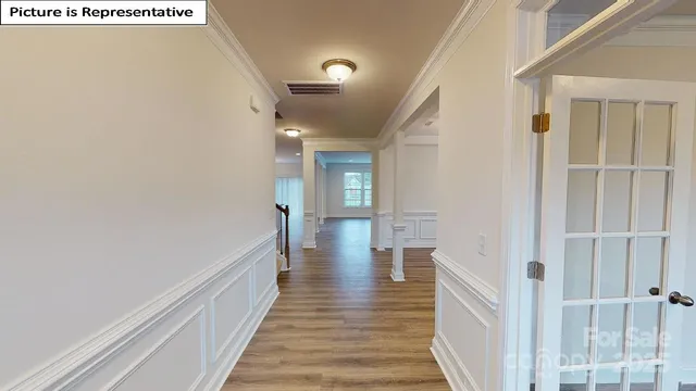 a view of a hallway with wooden floor and staircase