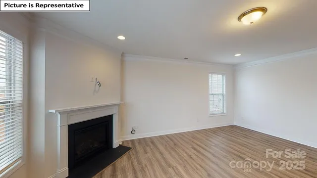 a view of empty room with wooden floor and fireplace