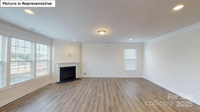 a view of empty room with wooden floor and fireplace