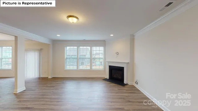 an empty room with wooden floor and fireplace