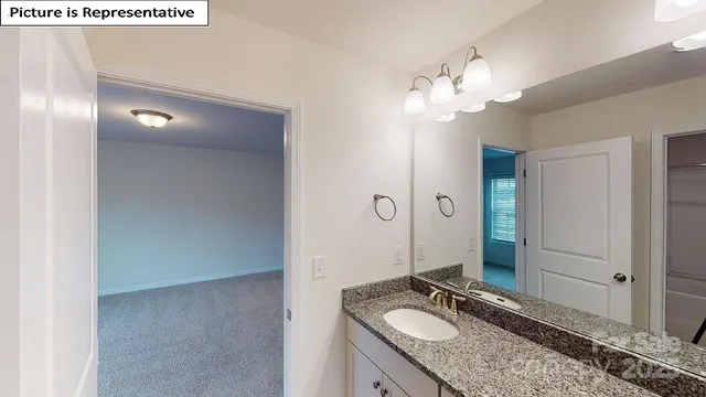 a bathroom with a granite countertop sink a light fixture and a mirror