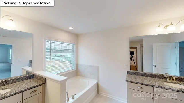 a bathroom with a granite countertop sink and a window