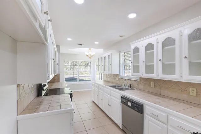 a large white kitchen with a large window