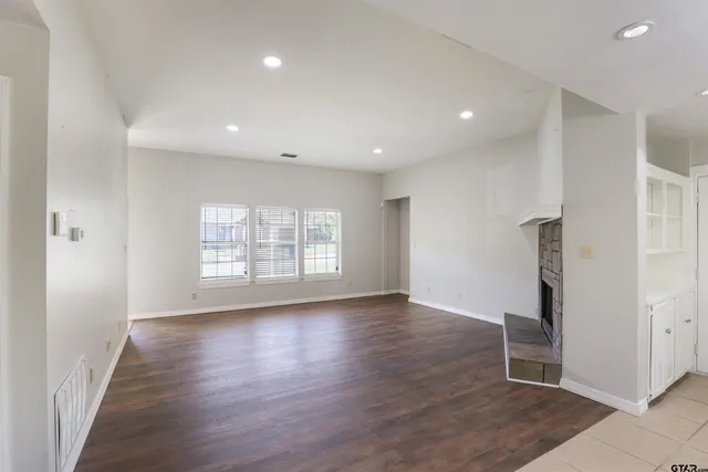 an empty room with wooden floor and a window