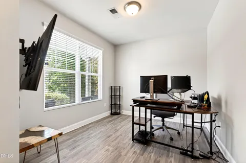 a view of a workspace with furniture and a window