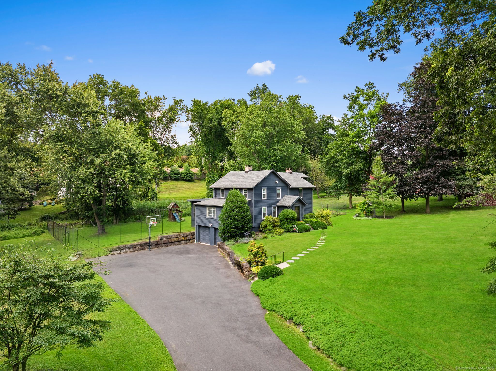 a view of a house with a big yard plants and large trees