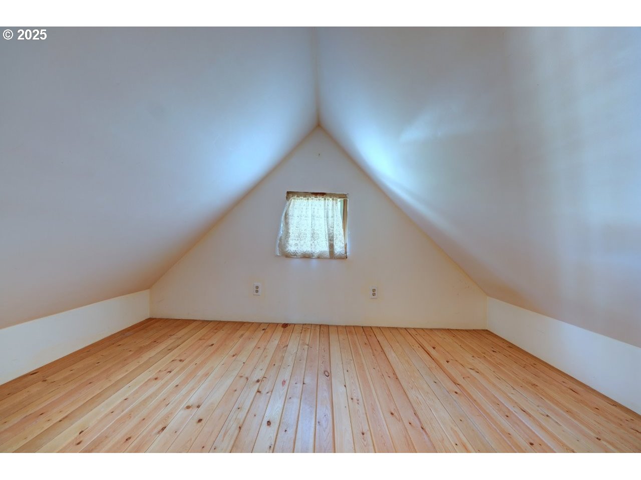 123 West 1st Street Cannon Beach, OR 97110 - Photo 8 of 35 a view of an empty room with wooden floor and a window