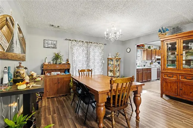 a dining room with furniture a chandelier and wooden floor