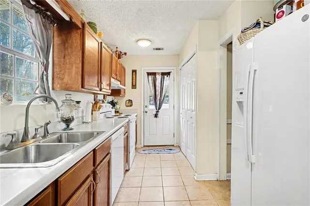 a kitchen with a sink refrigerator and cabinets