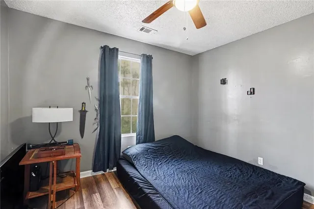 a bedroom with a bed and a wooden floor