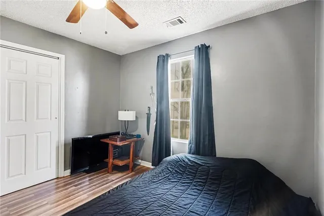 a bedroom with a bed and wooden floor