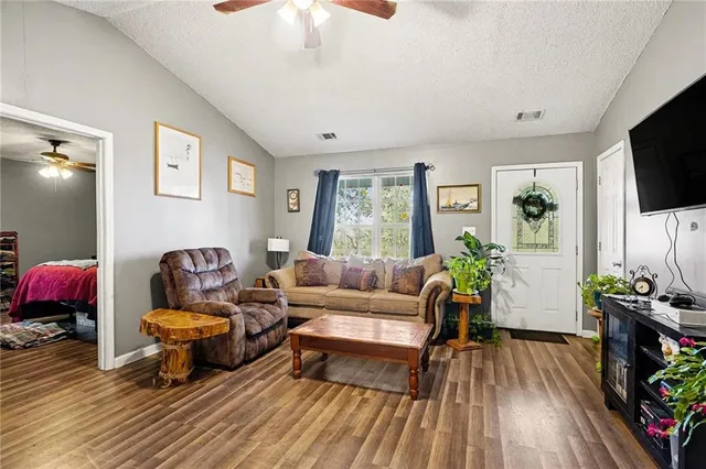 a living room with furniture a flat screen tv and a floor to ceiling window