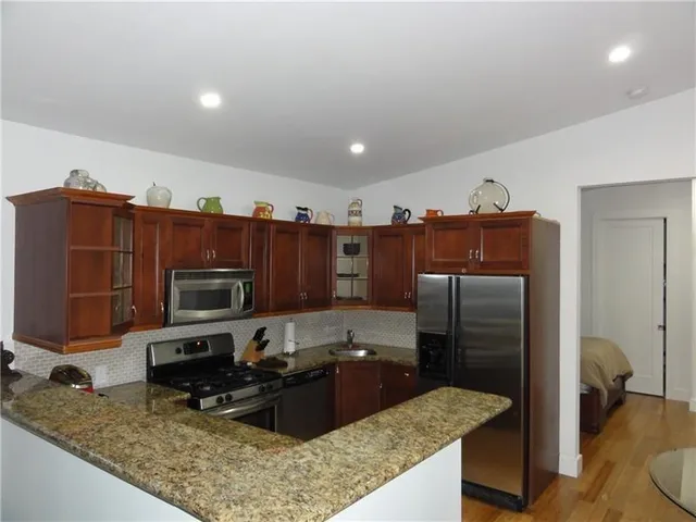 a kitchen with stainless steel appliances granite countertop a refrigerator stove and microwave