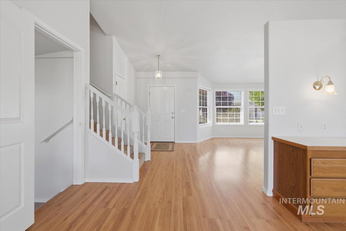 1128 West State Street Meridian, ID 83642 - Photo 11 of 50 Entryway featuring wood-finish flooring, white painted staircase, and a decorative pendant light