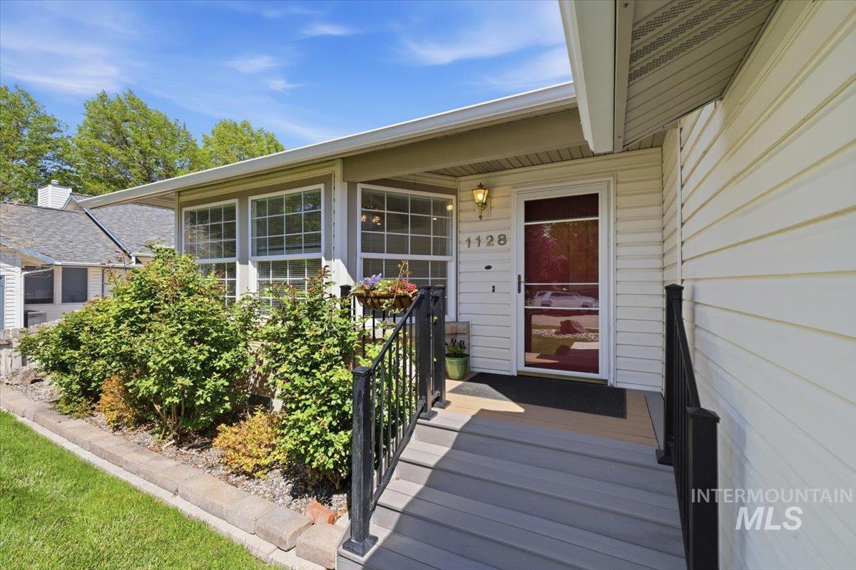 1128 West State Street Meridian, ID 83642 - Photo 2 of 50 Entryway featuring white siding, a red front door with a screen door, and a covered porch