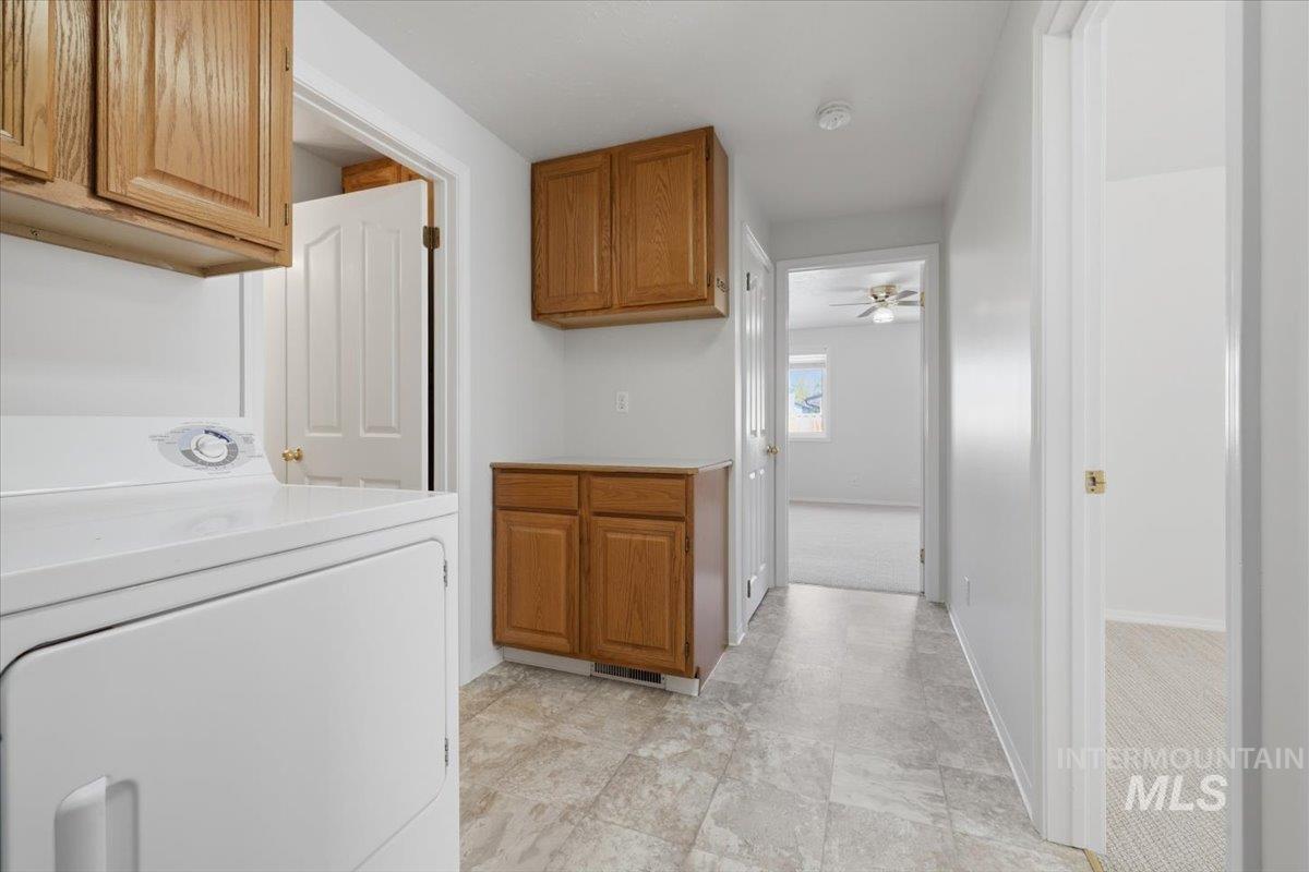 1128 West State Street Meridian, ID 83642 - Photo 27 of 50 Laundry area featuring wood-finish cabinetry, a built-in countertop, and neutral-toned flooring