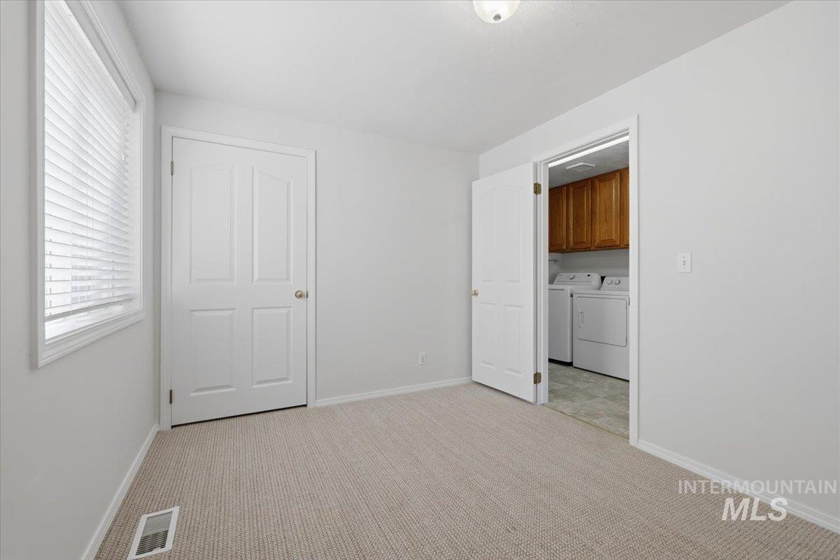 1128 West State Street Meridian, ID 83642 - Photo 29 of 50 Carpeted room with white walls, a single window with blinds, and a paneled door