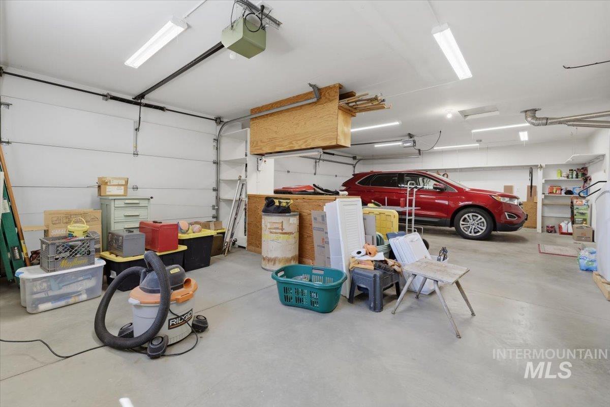 1128 West State Street Meridian, ID 83642 - Photo 30 of 50 Spacious garage featuring a concrete floor, overhead fluorescent lighting, and two overhead garage doors