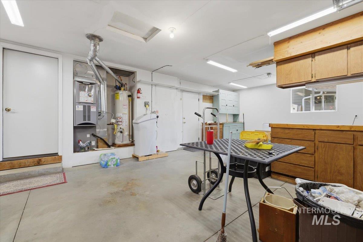 1128 West State Street Meridian, ID 83642 - Photo 31 of 50 Spacious utility area featuring exposed mechanical systems, overhead fluorescent lighting, a skylight, and built-in wood cabinetry with a laminate countertop
