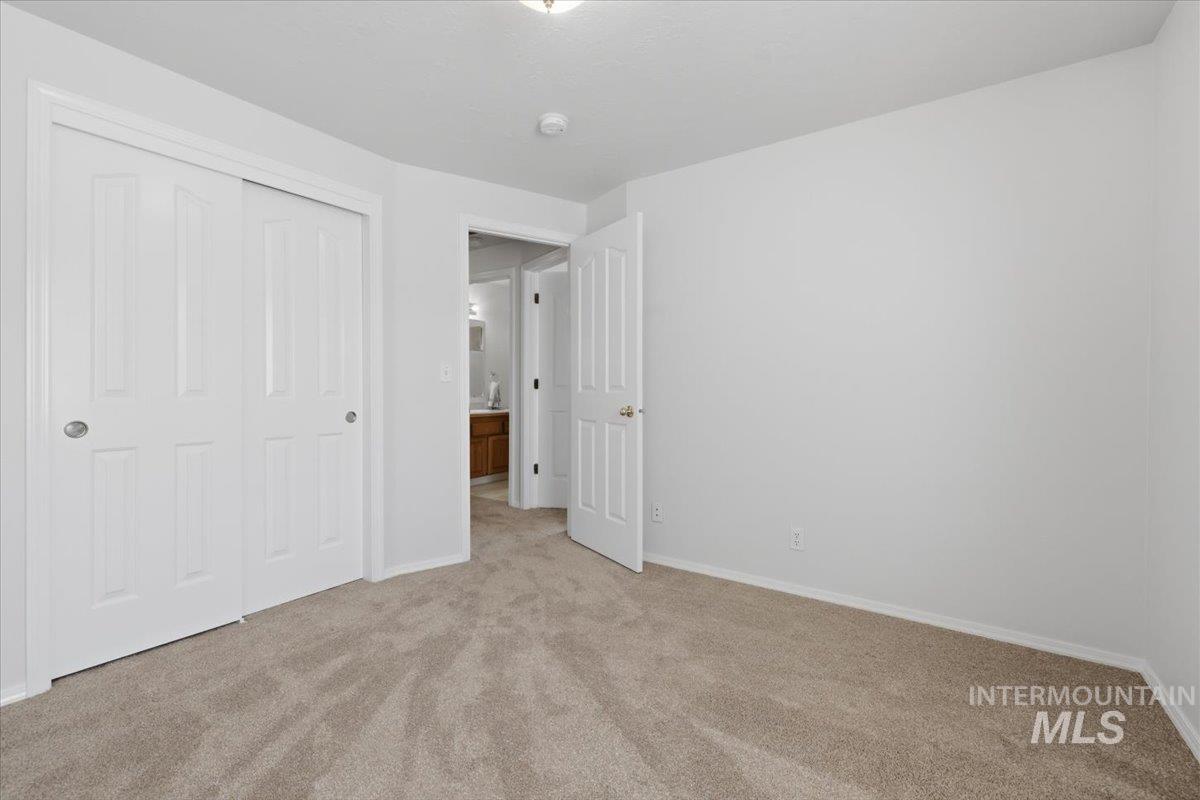 1128 West State Street Meridian, ID 83642 - Photo 36 of 50 Carpeted room featuring a white interior door, a two-panel sliding closet door, and light gray walls with white baseboards