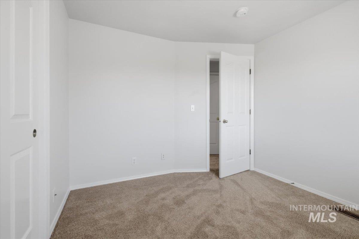 1128 West State Street Meridian, ID 83642 - Photo 37 of 50 Carpeted room featuring light neutral wall paint, white trim, and a white interior door