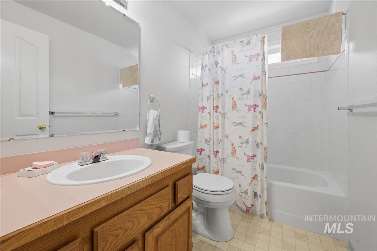 1128 West State Street Meridian, ID 83642 - Photo 38 of 50 Bathroom with a built-in wood-finish vanity, light pink countertop, and an integrated white sink