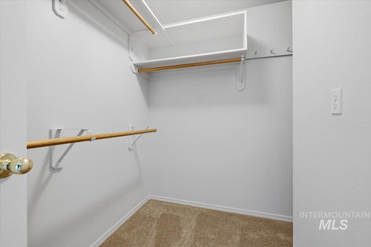 1128 West State Street Meridian, ID 83642 - Photo 41 of 50 Walk-in closet featuring carpeted flooring, white walls, and built-in shelving with hanging rods