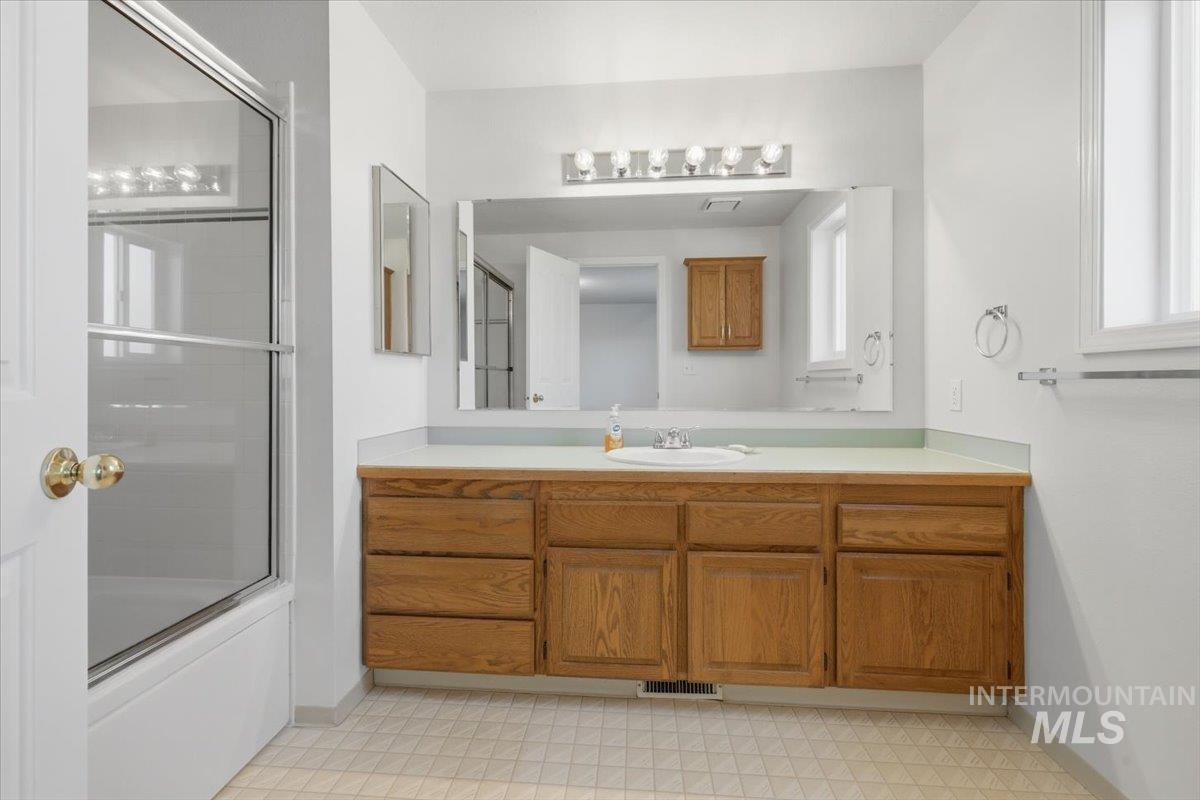 1128 West State Street Meridian, ID 83642 - Photo 42 of 50 Bathroom featuring a spacious wood-finish vanity with an integrated sink, a large wall-mounted mirror, and overhead strip lighting