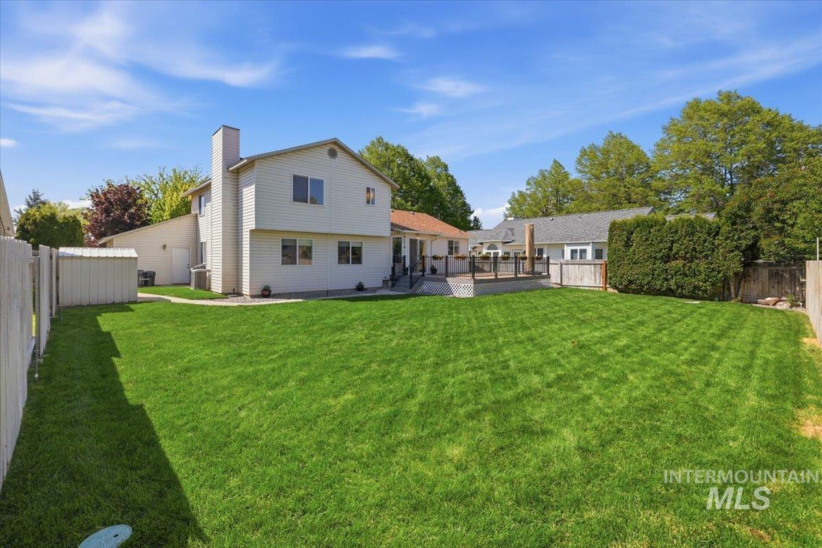 1128 West State Street Meridian, ID 83642 - Photo 43 of 50 Expansive green lawn with a two-story residence featuring white siding and a prominent chimney
