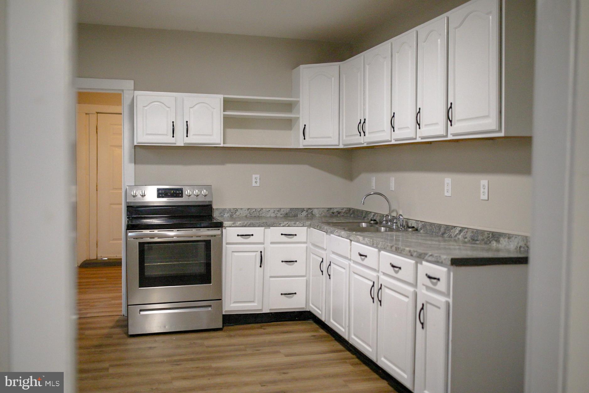 179 Main Street Hartly, DE 19953 - Photo 22 of 43 a kitchen with stainless steel appliances granite countertop a stove and a white cabinets