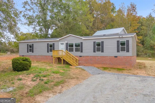 a view of a house with a yard and potted plants