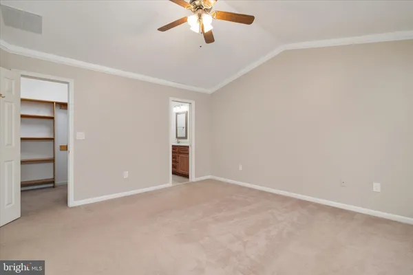 a view of an empty room and chandelier fan