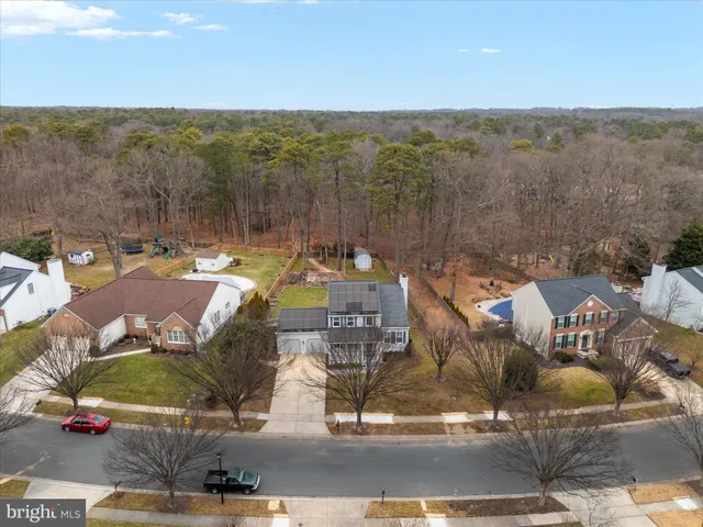 an aerial view of a house with swimming pool and large trees
