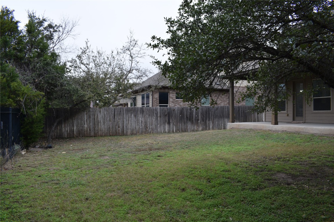 3001 Tempe Drive Cedar Park, TX 78641 - Photo 32 of 34 a view of a backyard with large trees and wooden fence