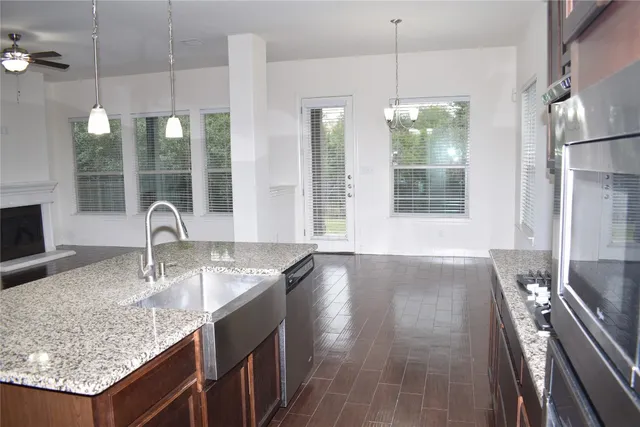 a kitchen with granite countertop sink and refrigerator
