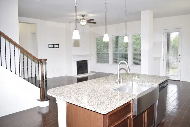 a kitchen with kitchen island granite countertop a sink and chandelier
