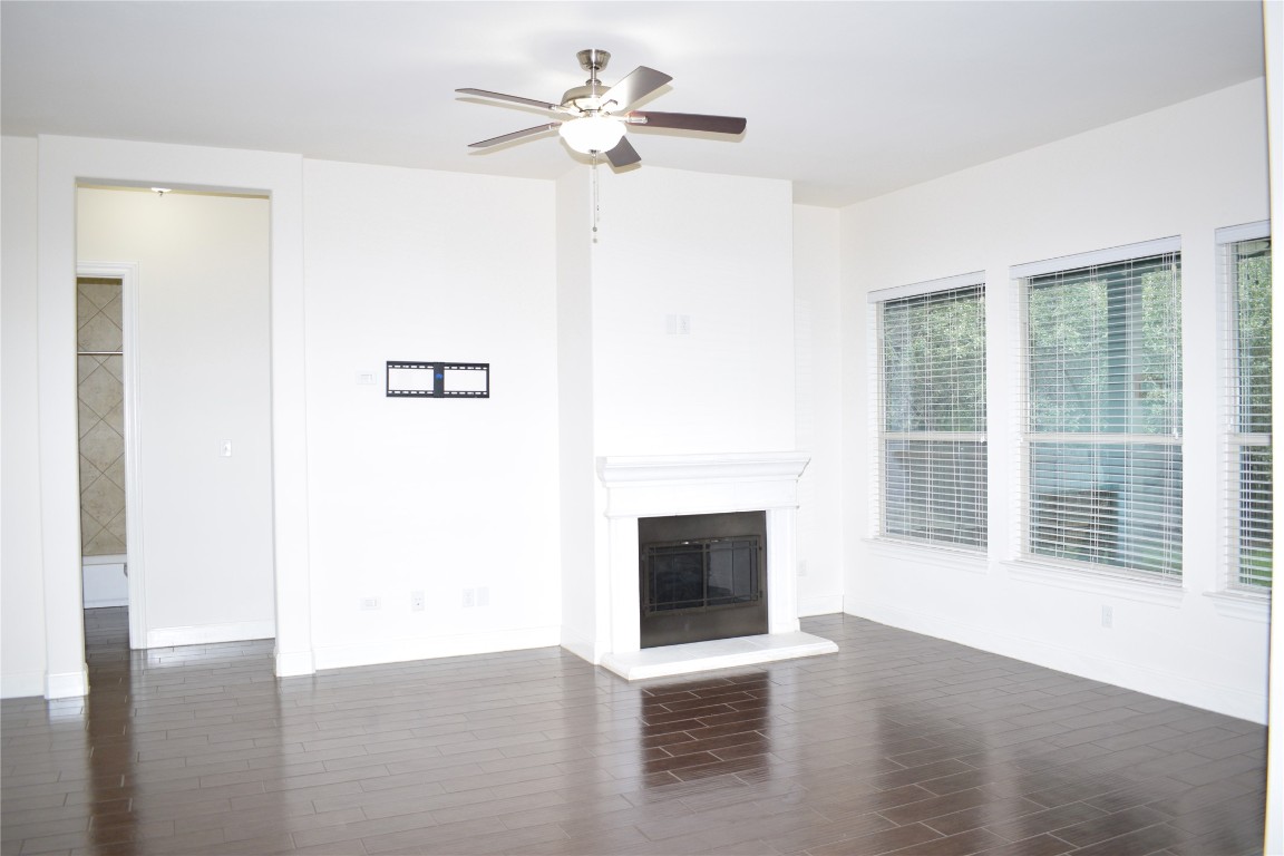 3001 Tempe Drive Cedar Park, TX 78641 - Photo 10 of 34 a view of a livingroom with a ceiling fan a fireplace and wooden floor