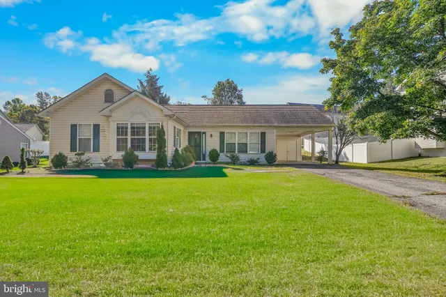 a front view of a house with a yard and potted plants