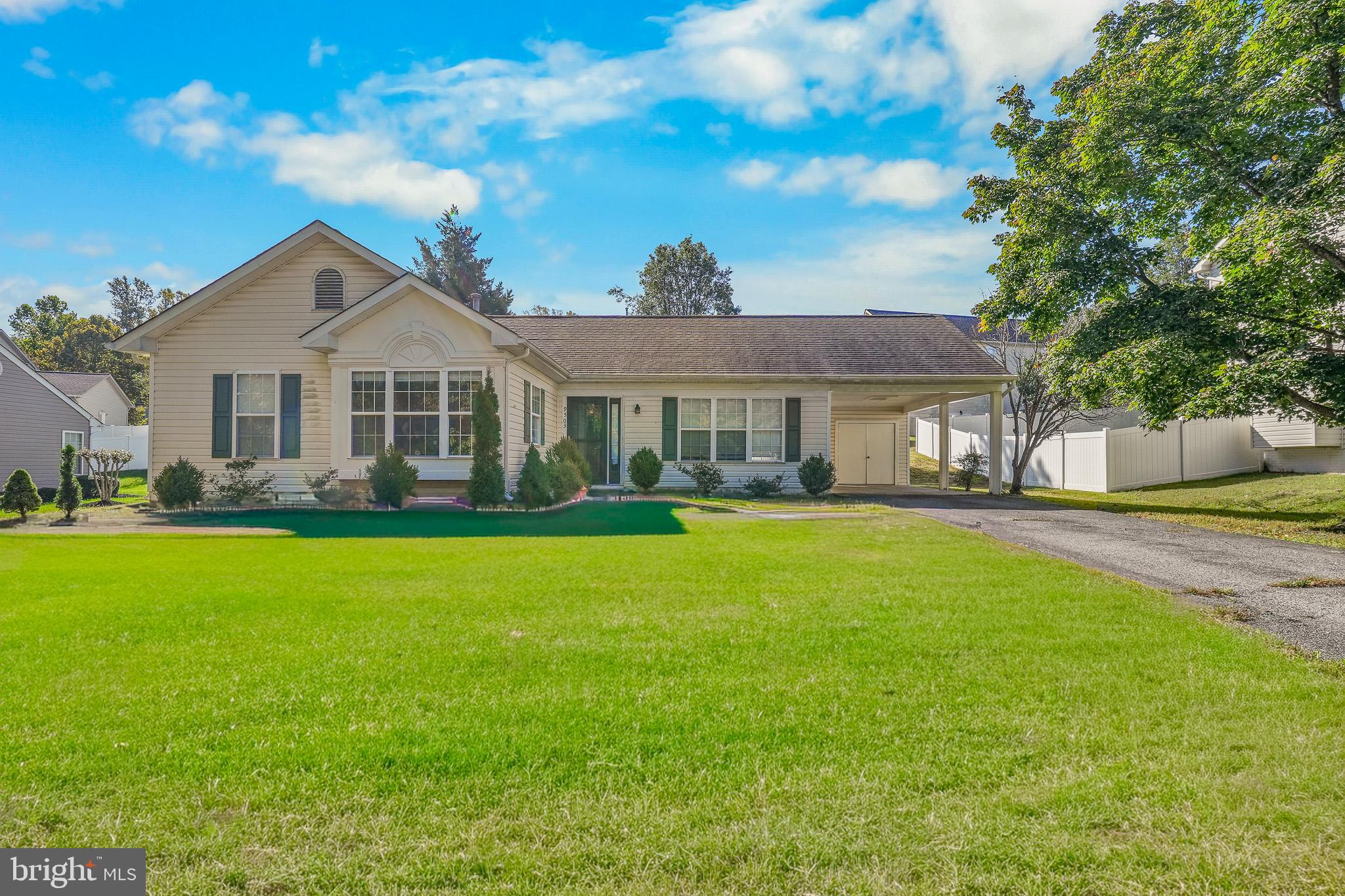 a front view of a house with a yard and potted plants