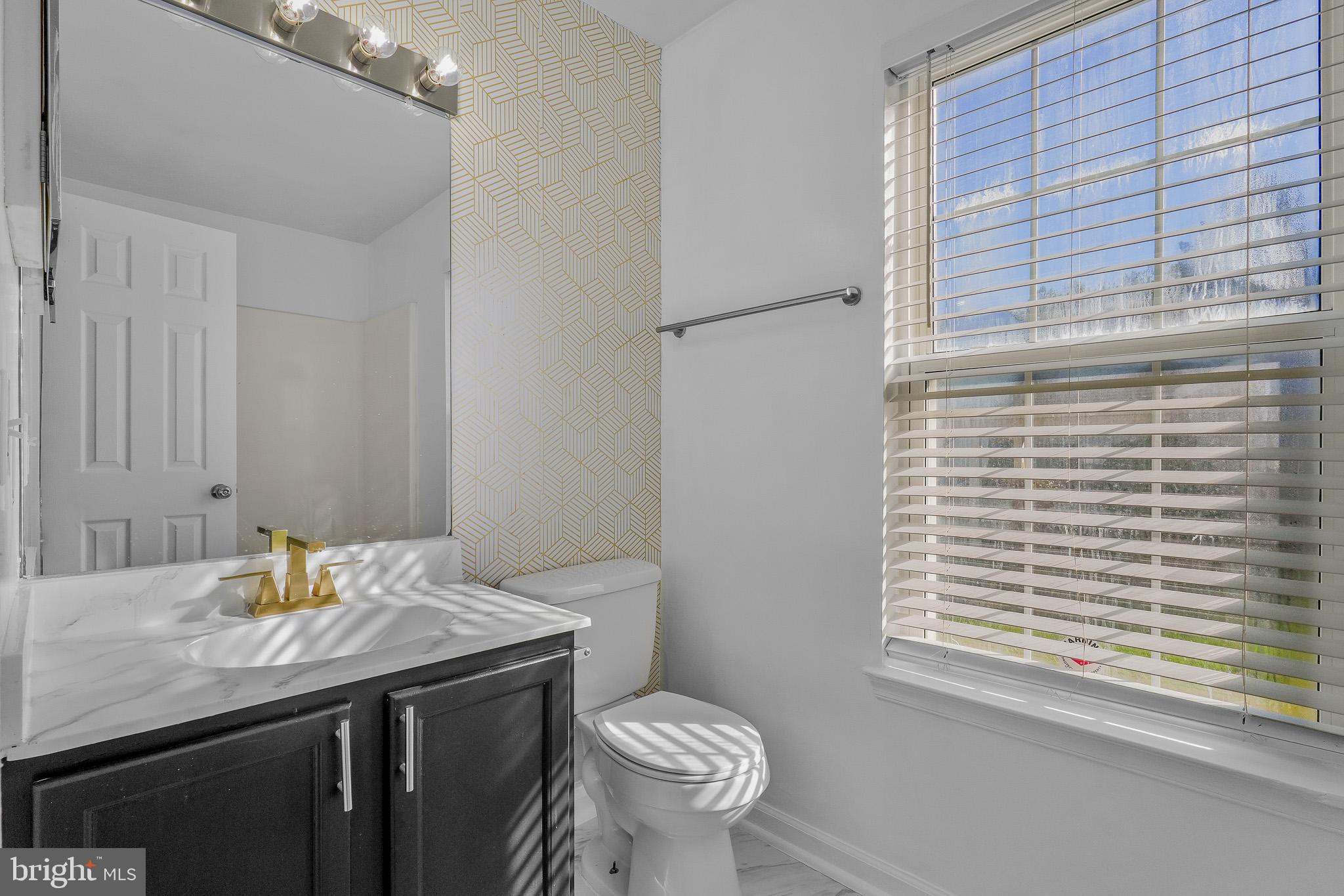 9503 Fletcher Avenue Clinton, MD 20735 - Photo 22 of 27 a bathroom with a granite countertop sink toilet and a mirror